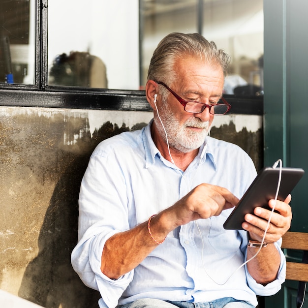 An elderly person using a tablet to access the Meu INSS app with a focus on maintaining updated personal information, illustrating the importance of keeping records current for accessing government benefits.