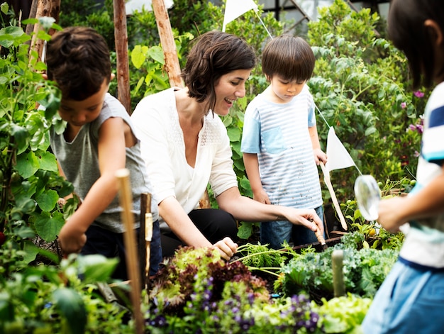 A group of volunteers planting vegetables in a community garden, with children and adults working together, sunny day, green environment.