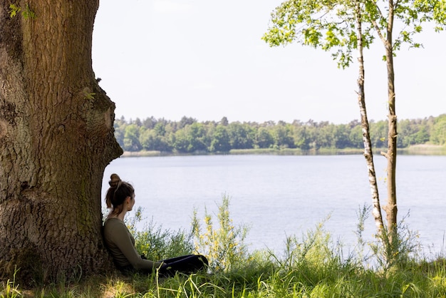 A person meditating in a peaceful setting, surrounded by nature, visualizing calmness and inner peace, suggesting the importance of emotional regulation in conflict resolution.