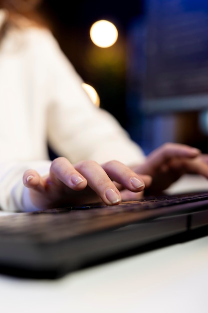 A close-up shot of hands typing on a laptop, with a blurred background of a modern co-working space. The focus is on the hands and keyboard, symbolizing digital literacy.