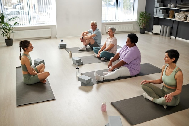 Seniors participating in a yoga class in a community center, focusing on their breathing and flexibility.