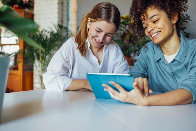 A friendly social worker assisting a woman with updating her Cadastro Único information on a tablet in a community center. The scene should portray a supportive and accessible environment.