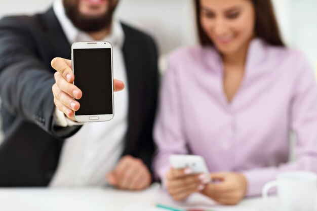 Someone showing the digital work card on their phone during a job interview being held in an office.