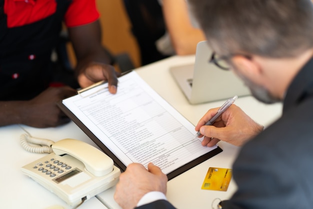 An individual filling out a form to correct their CPF information, surrounded by various identification documents like a passport and driver's license, emphasizing the importance of accurate personal data.