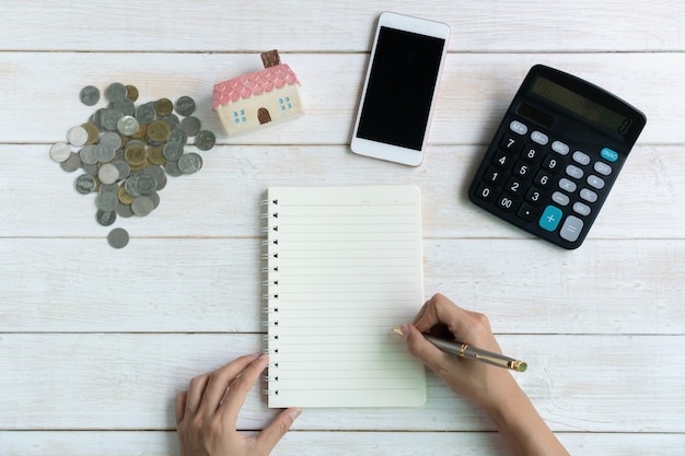 An image showing a person organizing bills and coins on a table, with a calculator and a budget planner nearby, symbolizing financial planning and careful spending.