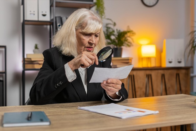 A person carefully examining a contract with a magnifying glass, highlighting the importance of due diligence before committing to a debt refinancing program.