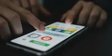 Pessoa acessando a Carteira de Trabalho Digital em um smartphone, com ícones de documentos e dados trabalhistas na tela.